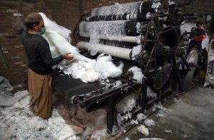 A laborer is busy filling pillows at a factory in Dabgari Garden.