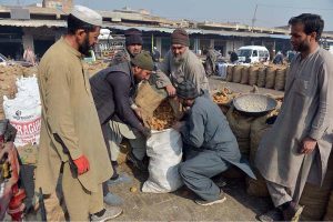 Labourers weigh traditional jaggery “Gur” for sale at Gur Mandi, meeting the city’s winter sweet cravings