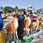 A vendor displays animal sculptures to attract customers along Eidgah Road.