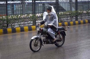 motorcyclist covered himself with a plastic sheet to protect from rain that experienced in the Provincial Capital.