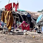 Gypsy woman preparing traditional bread outside her hut at Makki Shah area