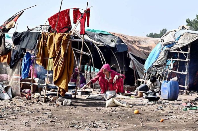 Gypsy woman preparing traditional bread outside her hut at Makki Shah area