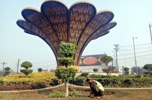 PHA worker busy planting saplings as plantation work continues around the Monument in Shahdara.