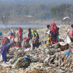 Gypsy people are searching valuables items from heap of garbage at Latifabad