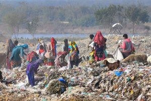 Gypsy people are searching valuables items from heap of garbage at Latifabad