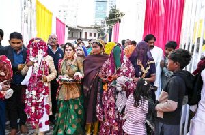 Brides and grooms enter a marriage hall during the 19th Combined Marriages Program, organized by the Pakistan Hindu Council at the Railway Ground.