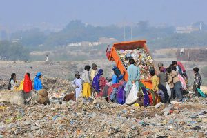Gypsy people are searching valuables items from heap of garbage at Latifabad