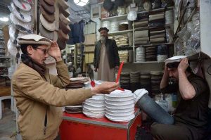 A craftsman stitches a traditional Chitrali cap at his workplace in Jahangir Pura Bazaar as demand for the cap rises during extreme cold weather in the city.
