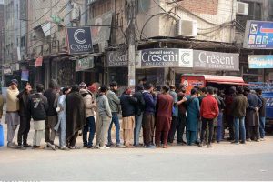 large number of people stand in a queue to receive free meals, highlighting ongoing relief efforts for the deserving in the city.