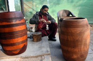 A shopkeeper crafts traditional big double-headed drums, locally known as "dhols," at his shop in Lahore’s historic Taksali Bazaar.
