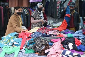 Women busy selecting and purchasing second hand warm clothes from vendor in weekly bazaar in the Federal Capital