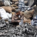 A vendor packs and sells charcoal to customers at his workplace outside Bhati Gate in the provincial capital.