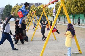 Children enjoying swings at Sukh Chayn Park in Federal Capital