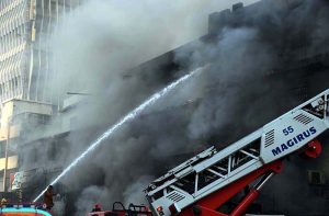 A view of Fire erupted last night at Gul Plaza shopping mall, and efforts to extinguish the massive blaze are still ongoing. Meanwhile, traders and their relatives are seen looking at the burnt mall
