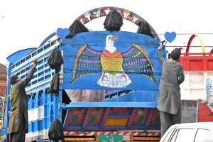 A vendor pushing handcart loaded with edible items to attract the customers