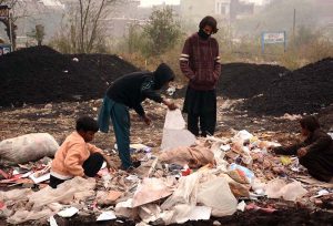 Gypsy youngsters search for valuables in a heap of garbage