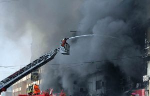 A view of Fire erupted last night at Gul Plaza shopping mall, and efforts to extinguish the massive blaze are still ongoing. Meanwhile, traders and their relatives are seen looking at the burnt mall