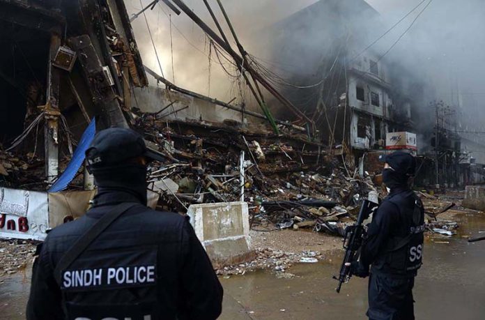 Special Security Unit (SSU) commandos are seen alert at the site of Gul Plaza, where a fire erupted last night