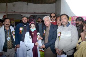 Federal Minister for Investment Board Qaiser Ahmad Sheikh giving shield to a doctor for best performance in medical camp at Moza Jhanb at Lahore Road