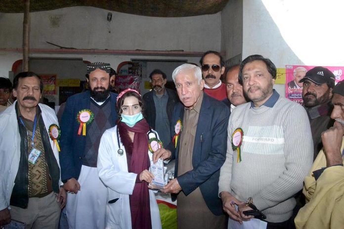 Federal Minister for Investment Board Qaiser Ahmad Sheikh giving shield to a doctor for best performance in medical camp at Moza Jhanb at Lahore Road