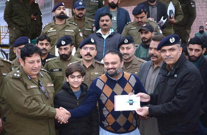 Regional Police Officer Sohail Sukhera and CPO Sahibzada Bilal Umar hand over vehicle keys to their original owners following the recovery in various cases at Police Lines