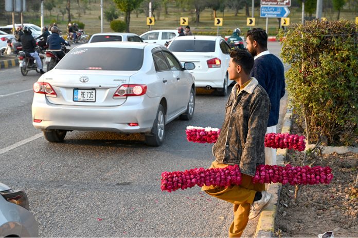 Young vendors selling floral bangles to attract customers at F-7 in the Federal Capital
