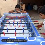 Youngsters playing board football game at Luhur Colony.