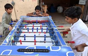 Youngsters playing board football game at Luhur Colony.