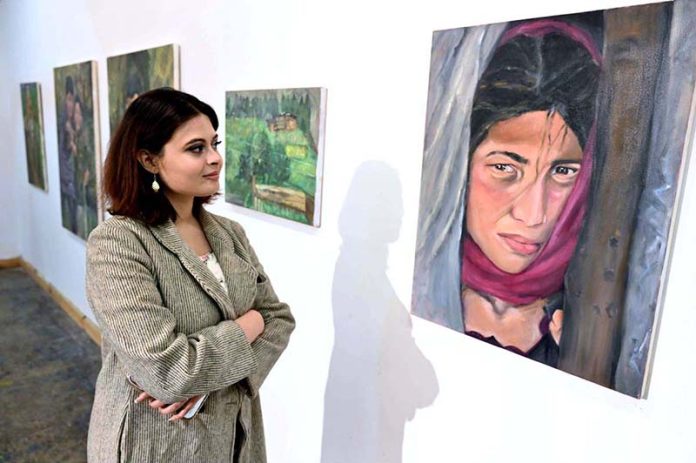 A visitor viewing the displayed art stuff during exhibition of Degree Show at NCA