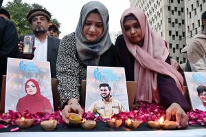 Members of the Human Rights Council of Pakistan light earthen oil lamps in tribute to the victims of the Gul Plaza fire, outside the Karachi Press Club