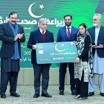Prime Minister Muhammad Shehbaz Sharif presenting a symbolic health card to a resident of Islamabad to mark the launch of PM's Health Card scheme