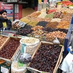 A young vendor arranging and selling the different kinds of Dry fruits to attract the customers on the roadside setup in the Provincial Capital