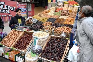 A young vendor arranging and selling the different kinds of Dry fruits to attract the customers on the roadside setup in the Provincial Capital