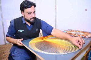 An artisan creating a piece of string art during International Tourism Conference & Exhibition Pakistan 2026 at a local hotel.