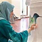 An artist paints on a bell during the launch of "Freedom 250 Liberty Bell" Initiative "Let Freedom Ring" at Lincein Corner in New USEFP building