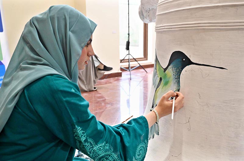 An artist paints on a bell during the launch of "Freedom 250 Liberty Bell" Initiative "Let Freedom Ring" at Lincein Corner in New USEFP building