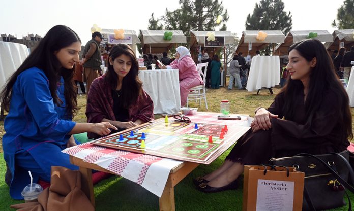 Young girls enjoy a game of ludo at the newly launched Community Market set up by the Capital Development Authority (CDA), aimed at promoting youth entrepreneurship and supporting local businesses amid the rising trend of informal pop-up markets in the Federal Capital