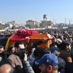 People gather to attend funeral prayers of victims following the suicide bombing at a religious site on the outskirts of the federal capital. Thousands of mourners, including federal ministers, attended the mass funeral.