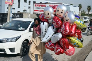 A vendor selling balloons to attract customers near Kuri road area in the city