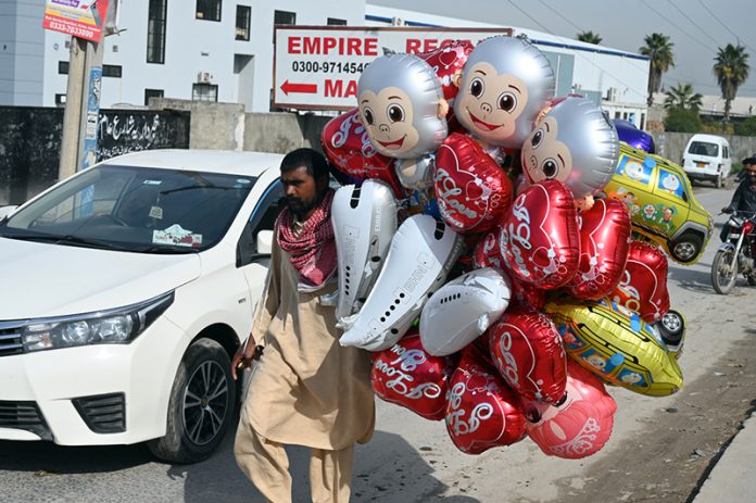 A vendor selling balloons to attract customers near Kuri road area in the city