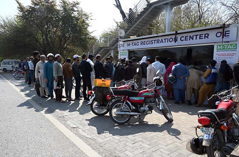 Motorcyclists wait in a queue for M-Tag installation at Kachnar Park after the Islamabad administration made M-Tag registration mandatory for all motorcycles from February 20, 2026, under the second phase of the capital’s vehicle tagging drive