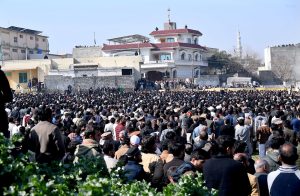 People gather to attend funeral prayers of victims following the suicide bombing at a religious site on the outskirts of the federal capital. Thousands of mourners, including federal ministers, attended the mass funeral.