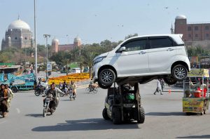 A traffic warden removing a wrongly parked car with the help of a forklift at Ghanta Ghar Chowk to ensure smooth flow of traffic in the City