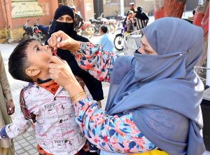 A lady health worker administering polio drops to a child during anti-polio campaign at Partabad Hospital