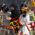 Girls look at artificial jewelry displayed for sale during the Faiz Festival at Alhamra