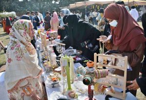A student tries to make a clay pot at a stall during the Gur Mela organized by the Directorate of Farms at the University of Agriculture, Faisalabad.