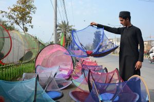 A vendor display mosquito nets to attract customers at roadside.