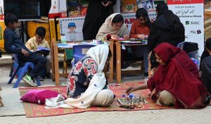 Girls look at artificial jewelry displayed for sale during the Faiz Festival at Alhamra