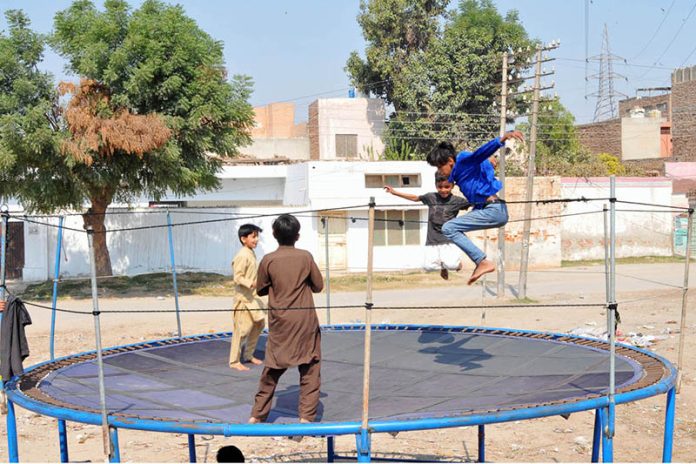 Children enjoying a fun-filled time as they jump and play on a trampoline set up in a neighborhood street area