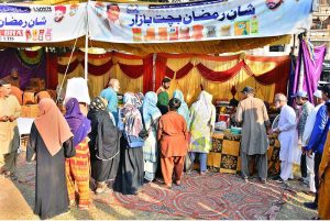 People purchasing grocery items from stalls in Ramazan Bachat Bazaar at Latifabad Unit Number 08 during holy month of Ramazan.